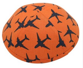 A bright orange iKIPPAH brand yarmulke with black planes on it.
